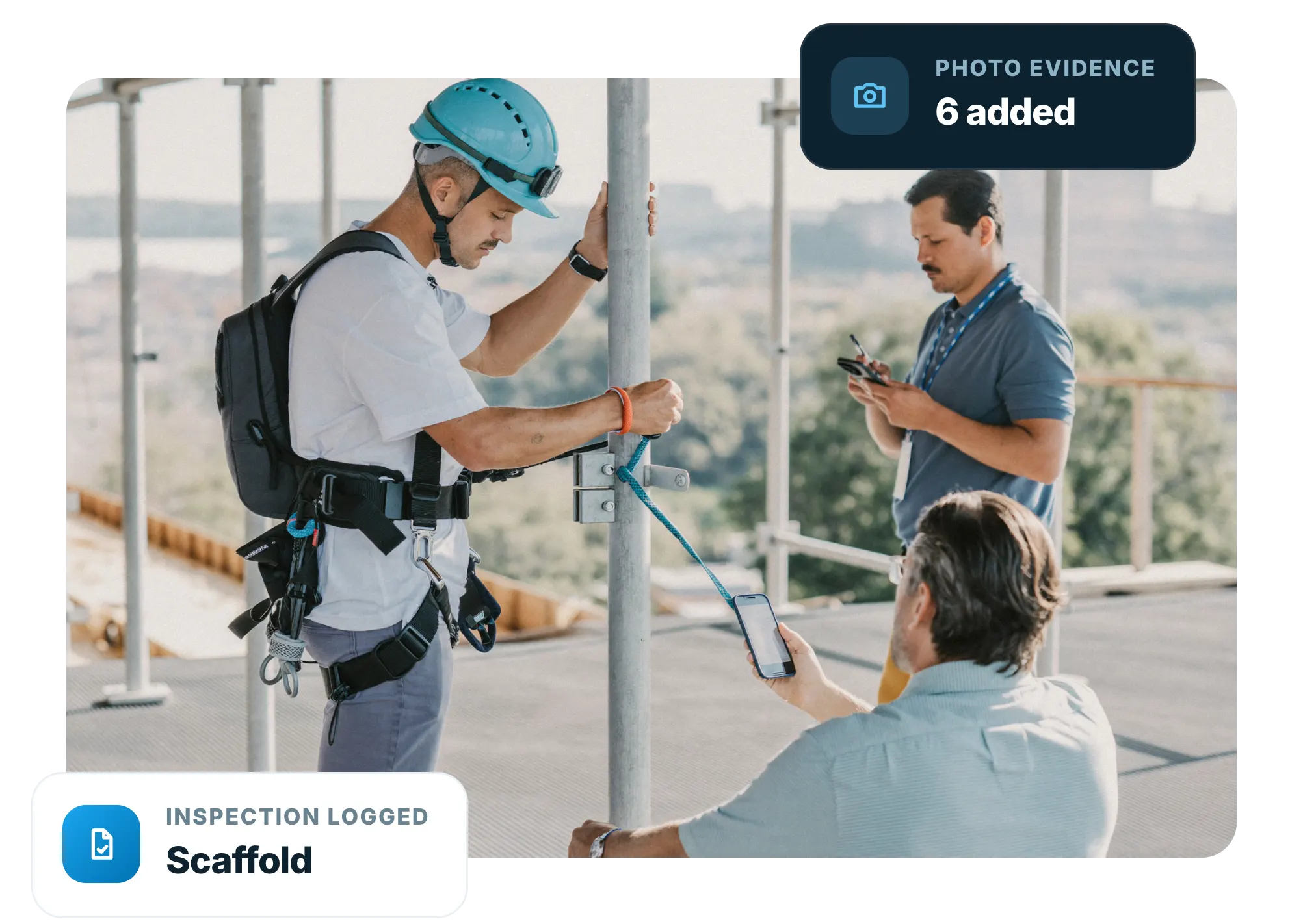 Scaffolder clipping on at height while a supervisor records the check on a phone