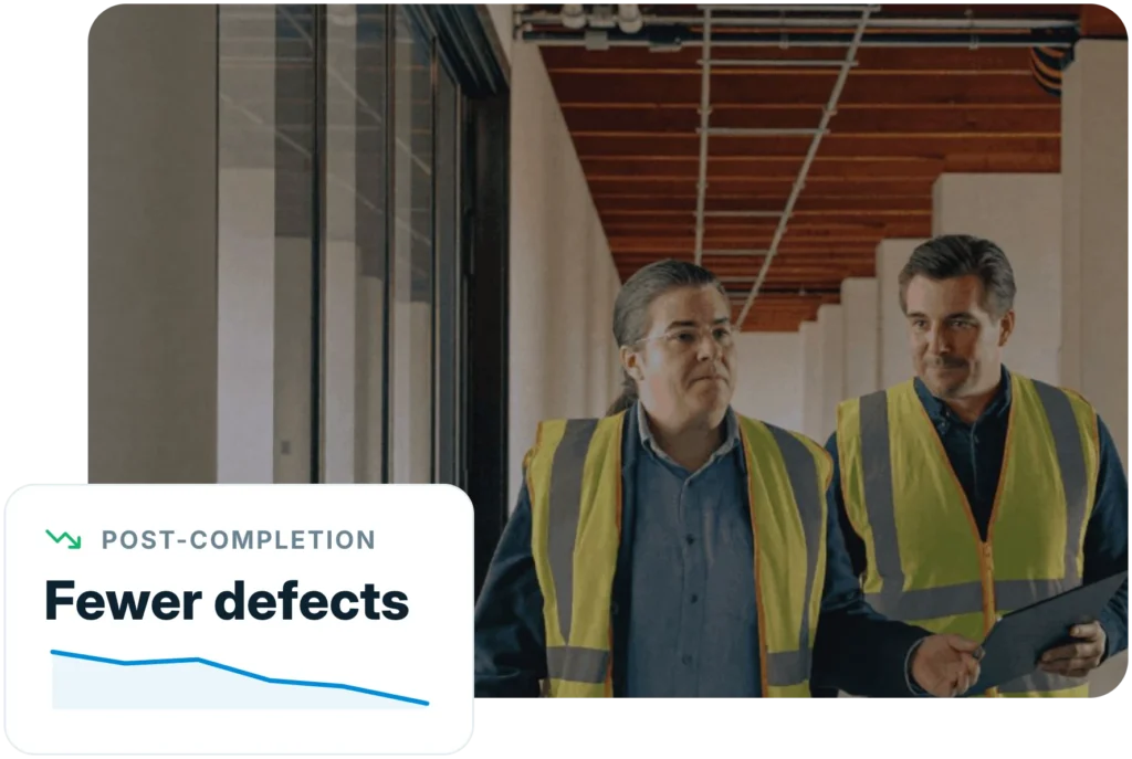 Two site managers walking a completed floor with an Insite report on a tablet, with post-completion defects trending down