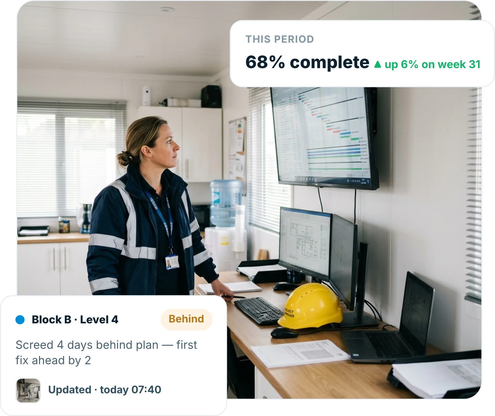 Project manager reviewing live project data on a monitor in a site office