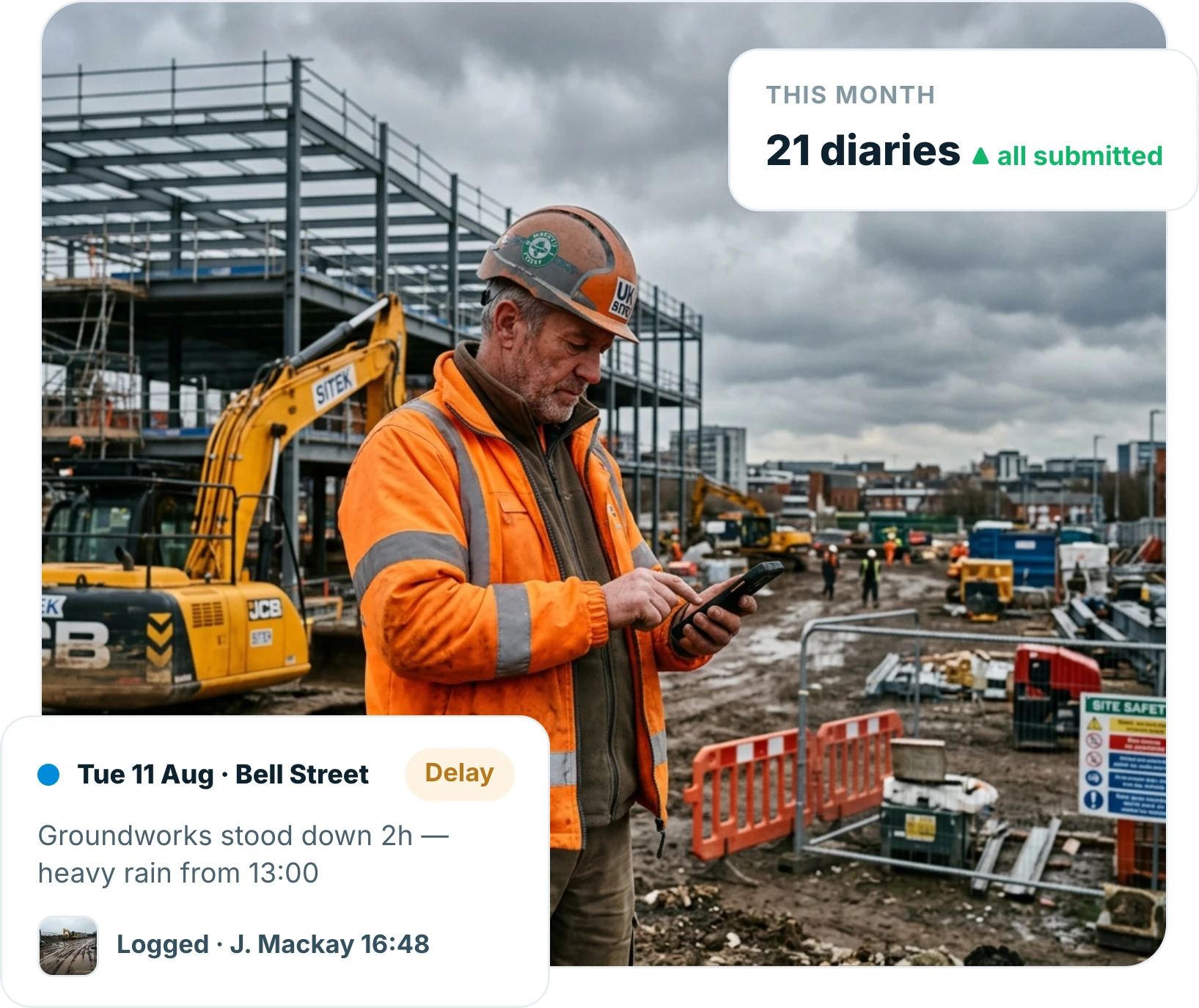 Site supervisor typing notes into a phone at the edge of an active groundworks site at the end of the day